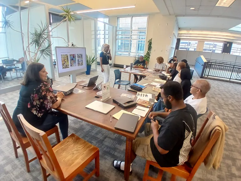 Youth and elders working together around a library table